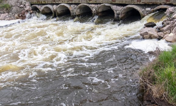 Environmental pollution, environmental disaster. Discharge of polluted sewage into the river from factory concrete pipes. Hazardous waste water. Environmental protection. Water pollution