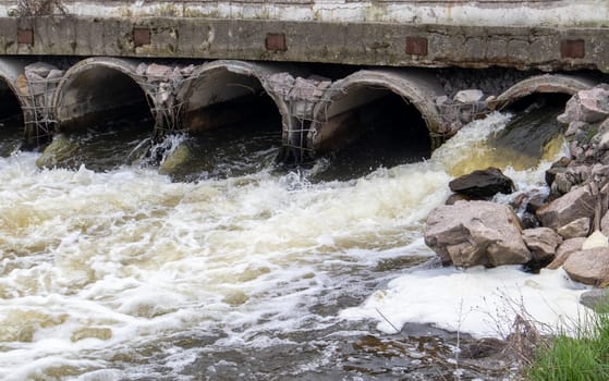 A concrete pipe that carries smelly, polluted sewage into the river through pipes. Pollution of the environment and water bodies. Ecological catastrophy. Hazardous waste water