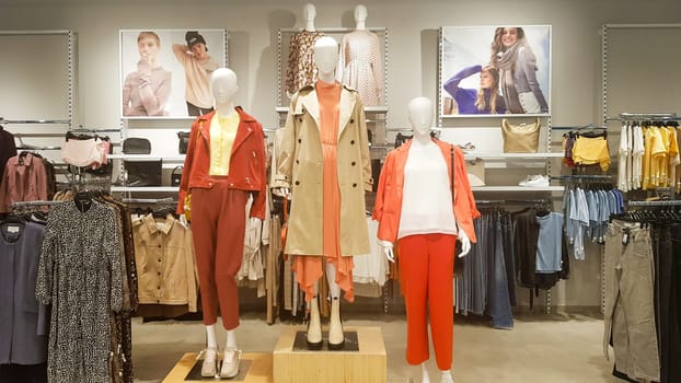 Three dressed mannequins standing in a store. Casual women's clothing store in the mall. Boutique mannequins in a fashion store. Shopping store without people. Ukraine, Kyiv - May 23, 2022