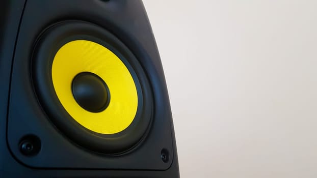 Speaker background. Woofer, yellow subwoofer close-up. Professional studio equipment. Vocal monitor for mixing and recording music. High quality desk monitors