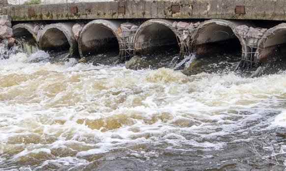 A concrete pipe that carries smelly, polluted sewage into the river through pipes. Pollution of the environment and water bodies. Ecological catastrophy. Hazardous waste water
