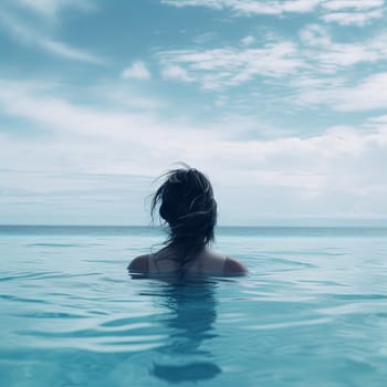 Rear view of woman in swimming pool while relaxing at resort. High quality photo