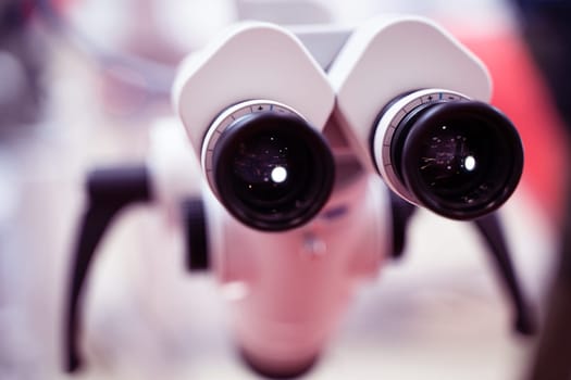 extreme closeup of medical microscope ocular black lenses with magnifying dials no people and shallow depth of field