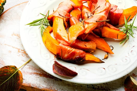 Autumn baked pumpkin pieces wrapped in bacon. Thanksgiving Day