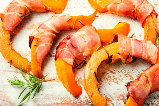 Autumn baked pumpkin pieces wrapped in bacon. Thanksgiving Day
