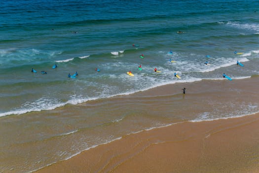 Sagres, Portugal - August 25, 2022: View of surfers on sandy beach near Sagres village in Algarve, Portugal