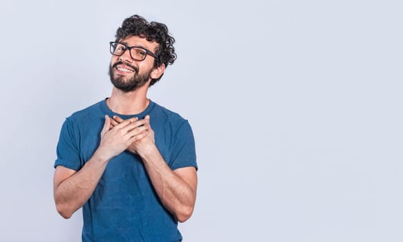 Grateful people smiling with hands on chest. Positive looking friendly handsome man with charming sincere smile feeling thankful, relaxed person with thanks gesture with hands on chest.