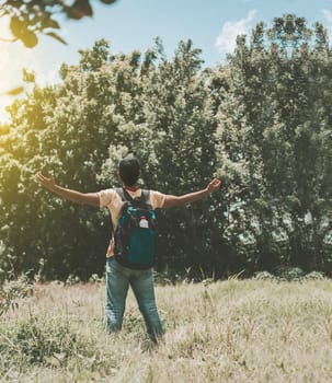 Backpacker man in the forest spreading his arms, Backpacker man in the forest spreading his arms, Rear view of hiker man spreading his arms in the forest
