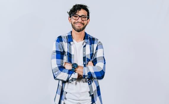 Friendly young man with crossed arms on isolated background. Teenage guy smiling with crossed arms isolated. Smiling bearded handsome man with crossed arms isolated