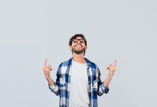 Smiling man in glasses pointing fingers up, People recommending something with fingers up isolated, Young man pointing an advertisement with fingers up