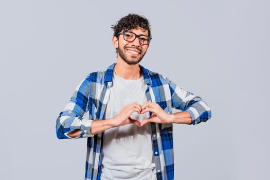Teenage guy making heart shape with hands isolated. Happy man making heart shape with hands isolated. Person putting hands together in a heart shape