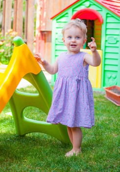 Portrait of 1 year old baby girl playing at home with the slide.