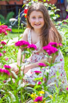 Portrait of a 10 year old girl enjoying the flower garden at home.