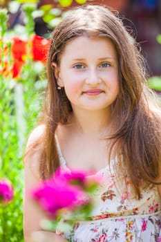 Portrait of a 10 year old girl enjoying the flower garden at home.