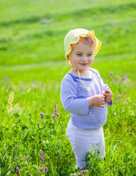Portrait of 1 year old baby girl enjoying a day on a meadow.