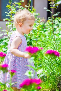 Portrait of 1 year old baby girl in the flower garden at home.