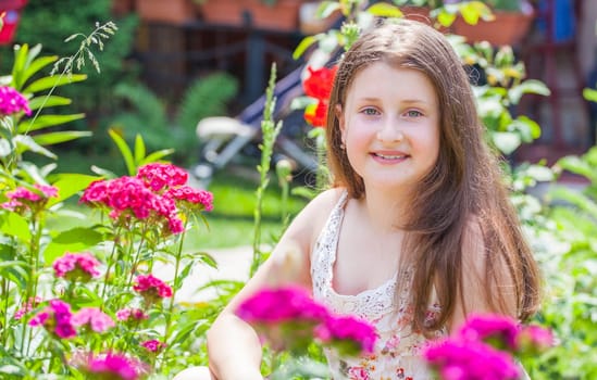 Portrait of a 10 year old girl enjoying the flower garden at home.