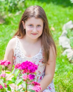 Portrait of a 10 year old girl enjoying the flower garden at home.