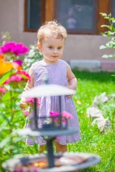 Portrait of 1 year old baby girl in the flower garden at home.