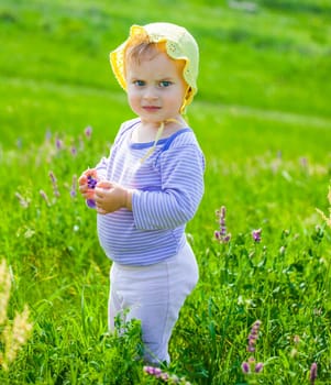 Portrait of 1 year old baby girl enjoying a day on a meadow.