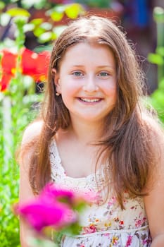 Portrait of a 10 year old girl enjoying the flower garden at home.