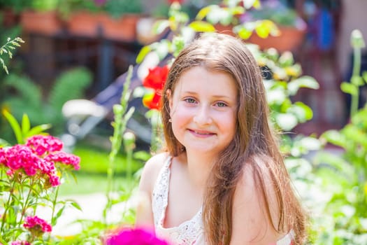 Portrait of a 10 year old girl enjoying the flower garden at home.