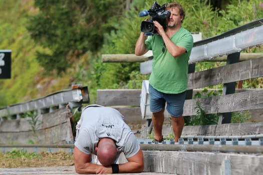 Totally exhausted,this runner takes a break at the Red Bull 400 - Germany premiere Titisee-Neustadt in front of a running TV camera
