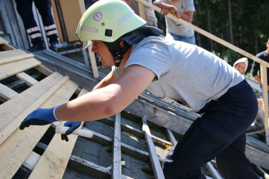 With helmet,relay wood and glove towards the finish - a firefighter of the fire brigade Marburg during the relay run over 4 x 100 meters at the Red Bull 400 - Germany premiere Titisee-Neustadt