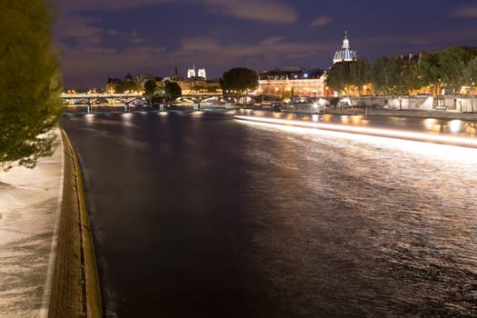 The River Seine in Paris, France overlooking downtown buildings and the Notre-Dame in the distance.