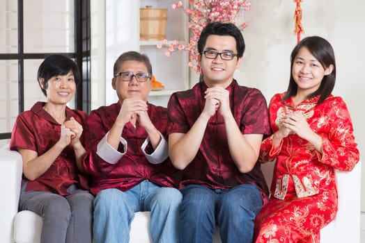 Happy Chinese new year. Happy Asian family in red cheongsam reunion and greeting at home.