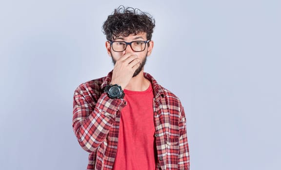 Person holding his nose looking at camera, people holding his nose with unpleasant smell expression, young man with bad smell expression holding his nose