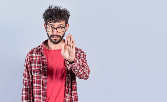 Portrait of handsome man making stop gesture with his palm. Serious man making stop sign with his palm. concept of person doing stop on isolated white background