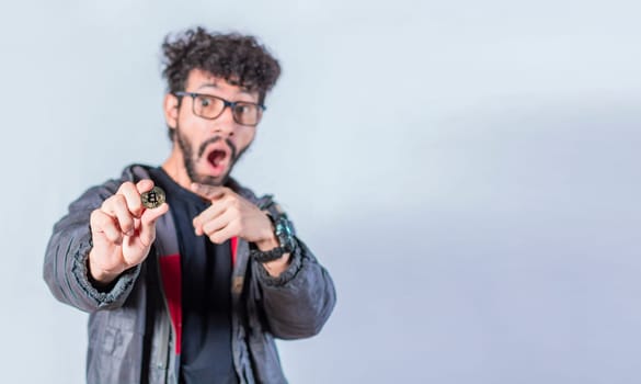 Surprised man holding bitcoin coin, Handsome man pointing bitcoin coin, Person holding bitcoin coin isolated