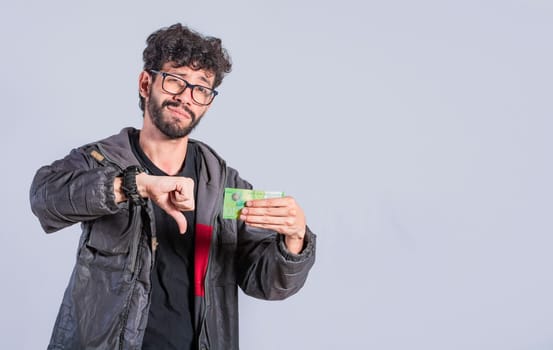 Concept of a person with money problems. Unhappy person with a Nicaraguan banknote with his thumb down,  Sad person with a bank note with his thumb down