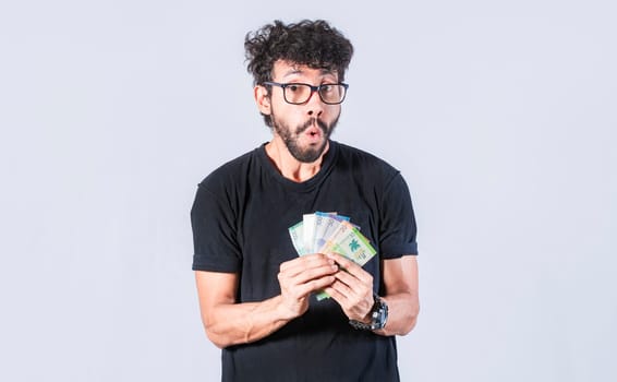 Amazed man with money in hand, man in glasses amazed with banknotes in hand, concept of man earning money