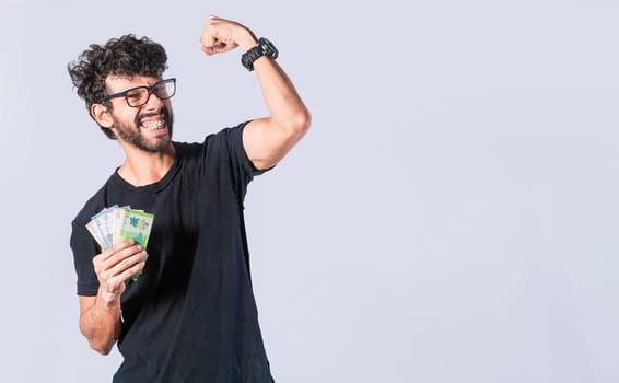 Happy man with money raising his fist, joyful man with bills in hand, concept of man with money isolated