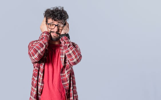 Man covering his ears on isolated background, a guy covering his ears, avoiding hearing, deaf ears concept