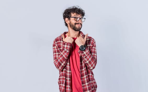 Handsome man pointing to the side, friendly guy pointing his fingers to the side, young man pointing at blank space