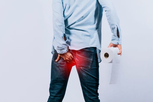 Man with toilet paper in hand touching his buttock, Man with diarrhea problem, man with hemorrhoid problem on isolated background