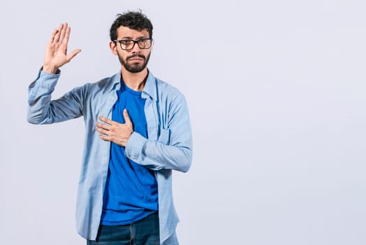 Man swearing honesty and devotion, Honest man raising his hand, a A guy raising his hand swearing, young man raising a hand promising something