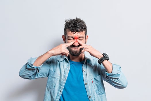 Man with nasal bridge headache, person with pain touching nose. sinus pain concept, A person with nasal bridge pain