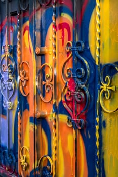The door of the house smeared with the colors and paints of graffiti artists. Vibrant colors.