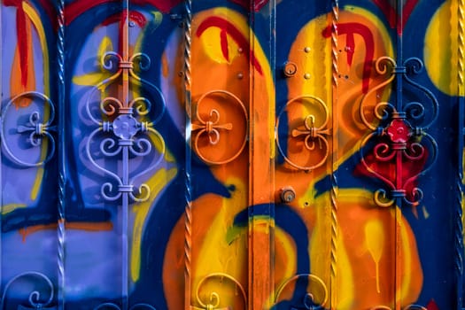 The door of the house smeared with the colors and paints of graffiti artists. Vibrant colors.