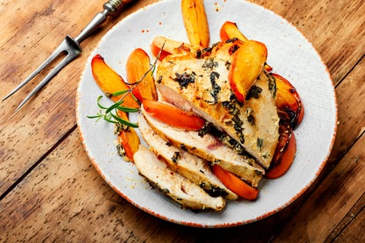 Chicken breast baked with persimmon on the plate. Healthy food