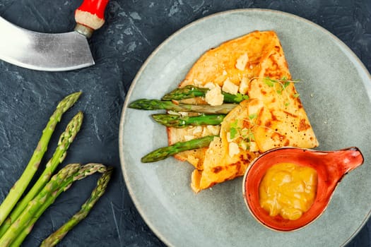 Tasty omelet or vegan crepes stuffed with green asparagus,cheese and herbs. Healthy breakfast.