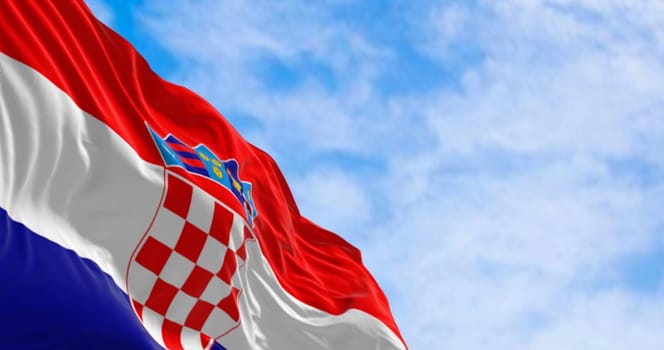 The national flag of Croatia waving in the wind on a clear day. Red, white and blue horizontal stripes with coat of arms in center. 3d illustration render. Fluttering fabric.