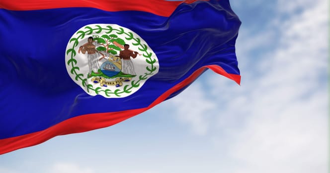 Belize national flag waving in the wind on a clear day. Blue field, red stripes top and bottom, white disk with National Coat of Arms. 3d illustration render. Fluttering fabric
