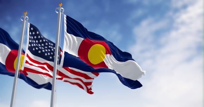 The Colorado state flag waving with the national flag of the United States of America on a clear day. 3D illustration render. Rippled textile