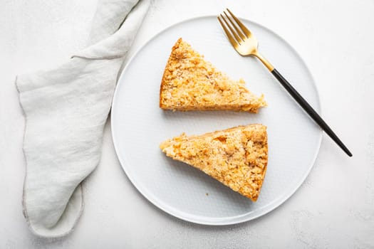 Two pieces of homemade apple pie with nuts on a plate.