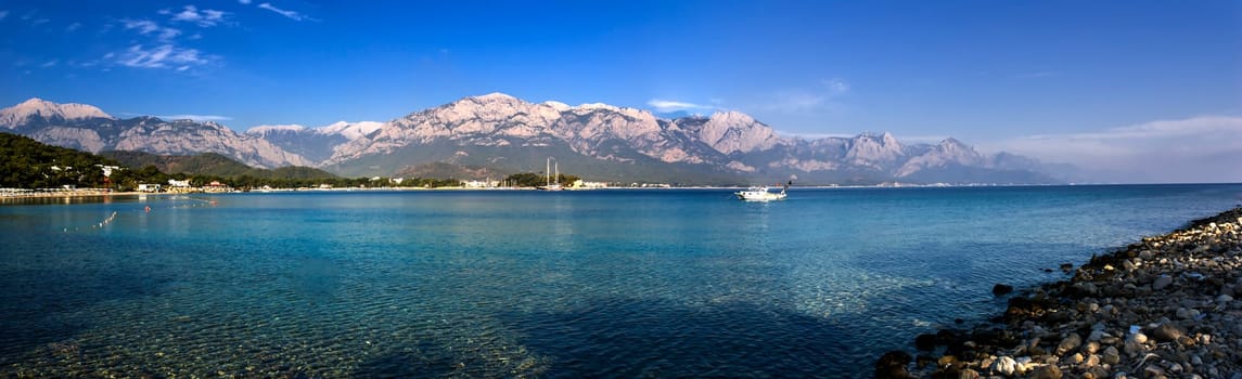 Kemer Antalia nice view of the sea. Beach Kemer Antalia with sand and mountains, the sea with the ship. Beautiful harbor near the sandy beach.
